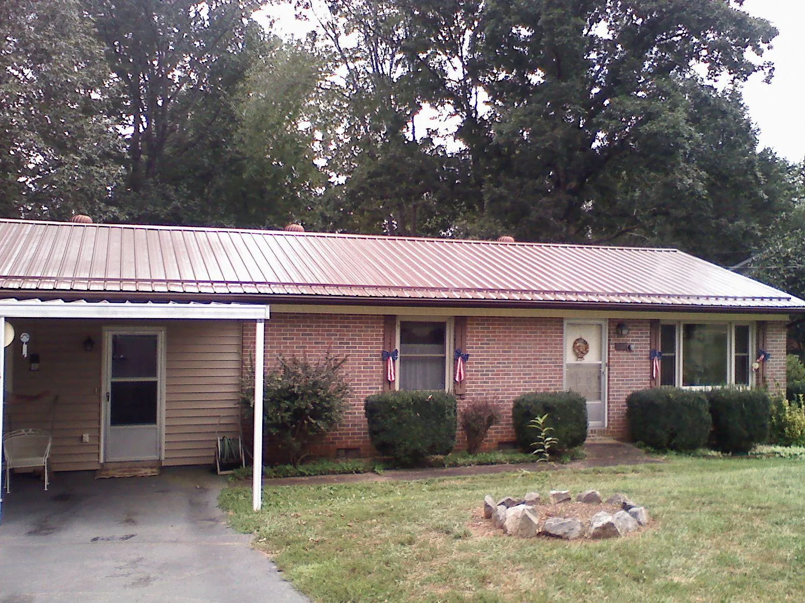 Bronze metal roof and carport on a brick ranch home — Roof Repair work by our crew in Wildwood